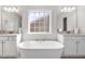 Bright white bathroom featuring a soaking tub between two sinks, and a grid patterned window at 330 Macallan Dr, Burlington, NC 27215