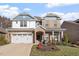 Charming two-story brick home with a well-manicured lawn, a two-car garage, and lovely front porch at 330 Macallan Dr, Burlington, NC 27215