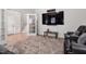 Cozy living room with large TV, black leather sofa, decorative rug, and access to other rooms at 330 Macallan Dr, Burlington, NC 27215