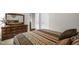 Cozy bedroom featuring a wooden dresser with mirror and comfortable bed with patterned bedding at 3345 Little Creek Church Rd, Clayton, NC 27520