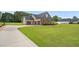 Sprawling lawn and three-car garage accentuate this brick home at 3345 Little Creek Church Rd, Clayton, NC 27520