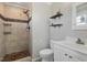 Modern bathroom features a beautifully tiled walk-in shower with a unique pebble floor and floating shelves at 3540 Sellars Rd, Mebane, NC 27302
