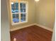 Bedroom with hardwood floors and a window offering natural light and outdoor views at 405 Starrett Ct, Raleigh, NC 27603