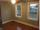 Bedroom with hardwood floors, two windows providing natural light, and neutral walls at 405 Starrett Ct, Raleigh, NC 27603