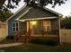 Charming home featuring blue siding, a cozy front porch with wood pillars and railings, and manicured landscaping at 405 Starrett Ct, Raleigh, NC 27603