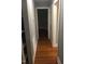 A hallway with hardwood floors leads to doorways, showcasing the home's layout and flow at 405 Starrett Ct, Raleigh, NC 27603