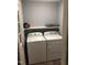 Functional laundry room with washer, dryer, and shelving for storage at 405 Starrett Ct, Raleigh, NC 27603
