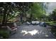Outdoor patio with pavers and comfortable seating, surrounded by mature trees and lush landscaping at 423 Oakland Dr, Raleigh, NC 27609