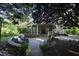 View of backyard featuring a patio with seating and lighting, lush landscaping, and privacy at 423 Oakland Dr, Raleigh, NC 27609
