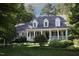 Charming home boasts a covered porch and beautifully landscaped front yard with mature trees at 423 Oakland Dr, Raleigh, NC 27609