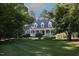 Traditional home featuring a manicured lawn, mature trees, and a charming front porch, perfect for southern living at 423 Oakland Dr, Raleigh, NC 27609