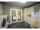 Bright laundry area with French doors to the deck, white cabinets, and modern washer and dryer at 423 Oakland Dr, Raleigh, NC 27609