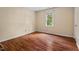 A bright bedroom featuring laminate flooring and a sunlit window with views of the outdoors at 4420 Tetbury Pl, Raleigh, NC 27613