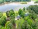 Aerial view of home with lake access, mature trees, and manicured lawn at 4612 River Farm Rd, Rocky Mount, NC 27803