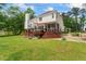 Spacious backyard featuring a wooden deck and steps leading to a screened porch on a sunny day at 4612 River Farm Rd, Rocky Mount, NC 27803
