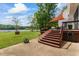 An inviting backyard featuring steps leading to a deck and screened porch, overlooking a body of water at 4612 River Farm Rd, Rocky Mount, NC 27803