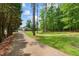 Long paved driveway leading to a charming home surrounded by lush green trees and landscaping at 4612 River Farm Rd, Rocky Mount, NC 27803