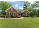 Lovely brick home with a manicured lawn and landscaping; featuring a covered porch and traditional windows at 4612 River Farm Rd, Rocky Mount, NC 27803