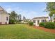Well-maintained backyard with lush lawn, landscaping, and a charming outbuilding at 48 Falling Oak Ct, Clayton, NC 27520