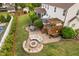Aerial view of backyard featuring a fire pit, stone patio, manicured lawn, and outdoor seating at 48 Falling Oak Ct, Clayton, NC 27520