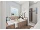 Luxury bathroom featuring a large bathtub, a window, and a glass-enclosed shower at 48 Falling Oak Ct, Clayton, NC 27520