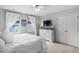 Bright bedroom featuring plush white bedding, neutral walls, and ample natural light from two windows at 48 Falling Oak Ct, Clayton, NC 27520