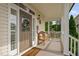 Inviting covered front porch with seating, a decorative wreath, and views of the front lawn at 48 Falling Oak Ct, Clayton, NC 27520