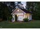 Illuminated garage exterior shows charming design and landscape at dusk at 48 Falling Oak Ct, Clayton, NC 27520