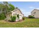 Detached garage with charming details, complimented by lush landscaping at 48 Falling Oak Ct, Clayton, NC 27520