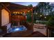 Outdoor hot tub and patio area featuring a covered pergola and tranquil landscaping at 48 Falling Oak Ct, Clayton, NC 27520