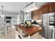 Kitchen area featuring a wooden island, stainless steel refrigerator and modern appliances at 48 Falling Oak Ct, Clayton, NC 27520