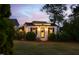Charming outbuilding with stylish details surrounded by manicured landscaping, lit for nighttime at 48 Falling Oak Ct, Clayton, NC 27520