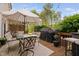 Stylish outdoor dining area with seating, a grill, and an umbrella for shade on the deck at 48 Falling Oak Ct, Clayton, NC 27520