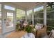 Bright sunroom featuring many windows, comfortable seating, and views of the private backyard at 48 Falling Oak Ct, Clayton, NC 27520