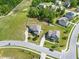 Aerial view of two-story homes with manicured lawns, driveways, and mature trees in a well-planned community at 5004 Clowser Minnow Ct, Wake Forest, NC 27587