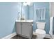 Bathroom with blue walls, gray cabinets, modern sink, and tile floors at 5004 Clowser Minnow Ct, Wake Forest, NC 27587