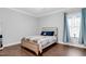 Cozy bedroom with hardwood floors, natural light, and a comfortable bed with a plaid blanket at 5004 Clowser Minnow Ct, Wake Forest, NC 27587