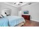 This large bedroom boasts a tray ceiling, wood floors, tv and dresser at 5004 Clowser Minnow Ct, Wake Forest, NC 27587