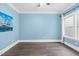 A bedroom with blue walls, hardwood floors, and ample natural light at 5004 Clowser Minnow Ct, Wake Forest, NC 27587