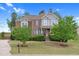 Attractive brick home featuring manicured lawn, mature trees, and a classic architectural design at 5004 Clowser Minnow Ct, Wake Forest, NC 27587