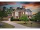 Charming two-story brick home with inviting curb appeal, professional landscaping, and a picturesque sunset backdrop at 5004 Clowser Minnow Ct, Wake Forest, NC 27587