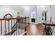 Hallway with hardwood floors and wood-and-iron banisters, leading to bedrooms and bathrooms at 5004 Clowser Minnow Ct, Wake Forest, NC 27587
