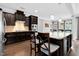 Kitchen island features granite countertop, dark wood cabinetry, barstool seating and pendant lighting at 5004 Clowser Minnow Ct, Wake Forest, NC 27587
