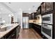 Kitchen features granite counters, stainless steel appliances, tile backsplash and dark wood cabinetry at 5004 Clowser Minnow Ct, Wake Forest, NC 27587