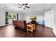 Spacious living area boasts a ceiling fan, leather sofa, and natural light from a window at 5004 Clowser Minnow Ct, Wake Forest, NC 27587