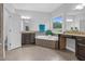 Bright main bathroom featuring a large window, double vanity sinks, and a soaking tub at 5004 Clowser Minnow Ct, Wake Forest, NC 27587