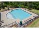 Top-down shot of the community pool featuring tables with umbrellas and lounge chairs within a gated space at 5004 Clowser Minnow Ct, Wake Forest, NC 27587