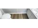Neutral bathroom featuring wood grain flooring, toilet, vanity with white sink and grey countertop at 5078 Flint Ridge Pl, Raleigh, NC 27609