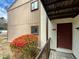 Charming home exterior with a cozy entryway, red door, and blooming azalea bush at 5078 Flint Ridge Pl, Raleigh, NC 27609