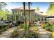 Back of home featuring a sunroom, deck, patio, lush landscaping, and a stone walkway at 5129 Bartons Enclave Ln, Raleigh, NC 27613